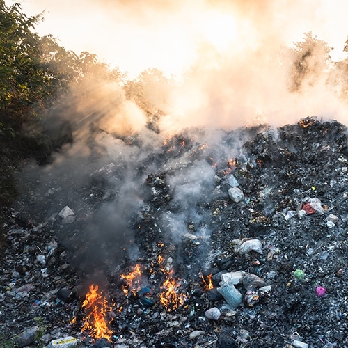 Garbage and fire burn in landfill